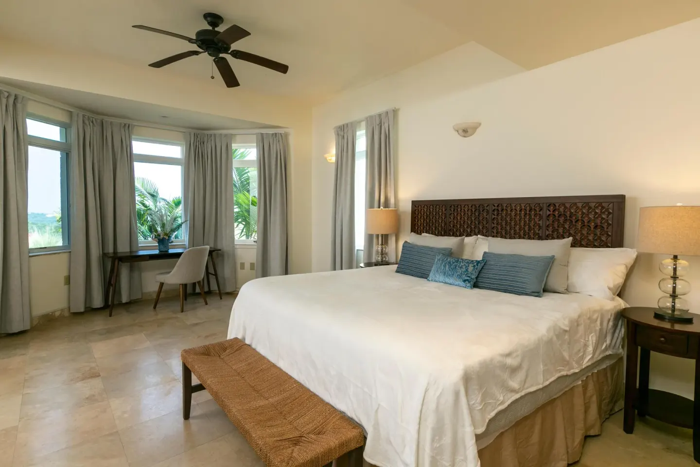 Guest room with king bed, bench, and writing desk at The Hills, St John.