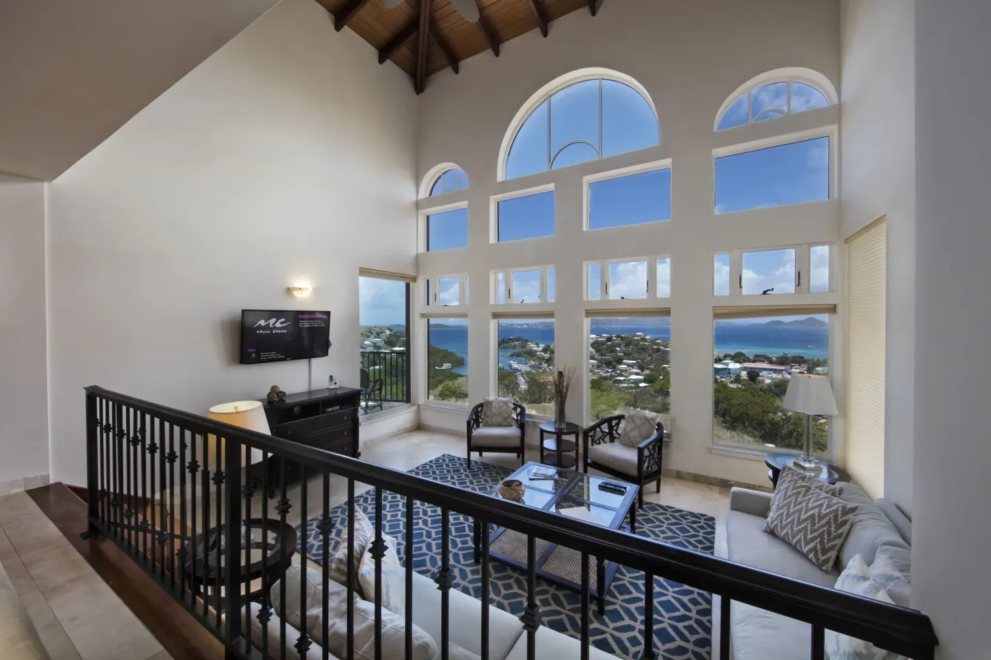 High-ceiling living room with arched windows and sea views at The Hills, St John.