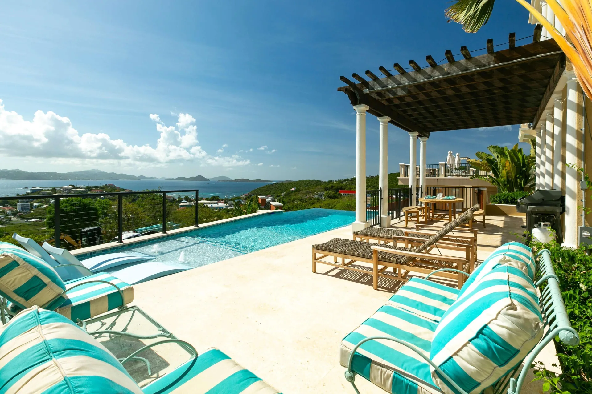 Infinity pool terrace with striped loungers and island views at The Hills, St John.