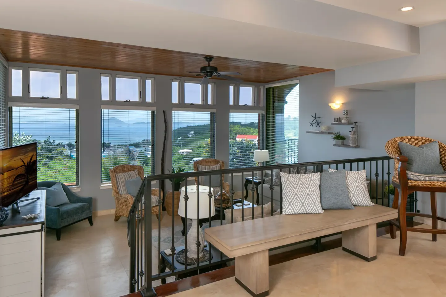 Loft seating area overlooking a windowed living room at The Hills, St John.