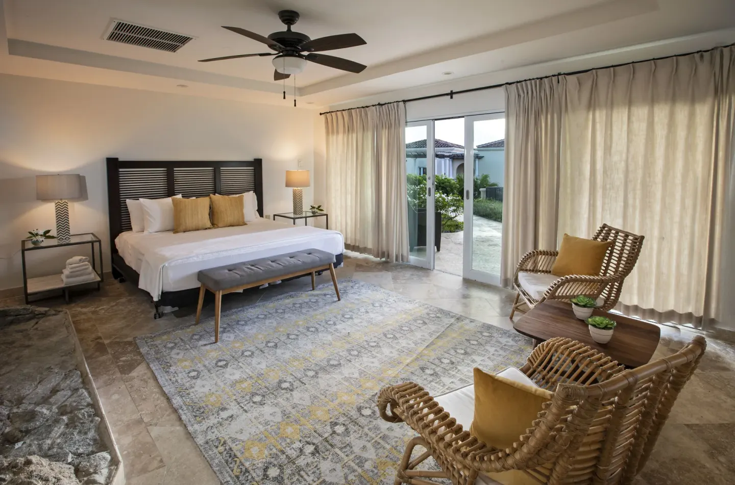 King bedroom with sitting area, ceiling fan, and sliding glass doors at The Hills, St John.