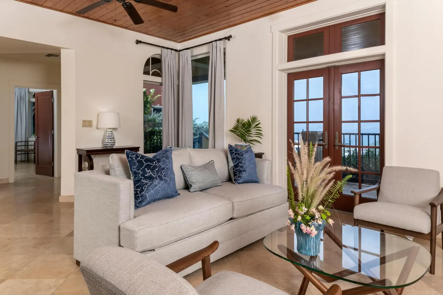 Sitting area with sofa, glass table, and French doors at The Hills, St John.