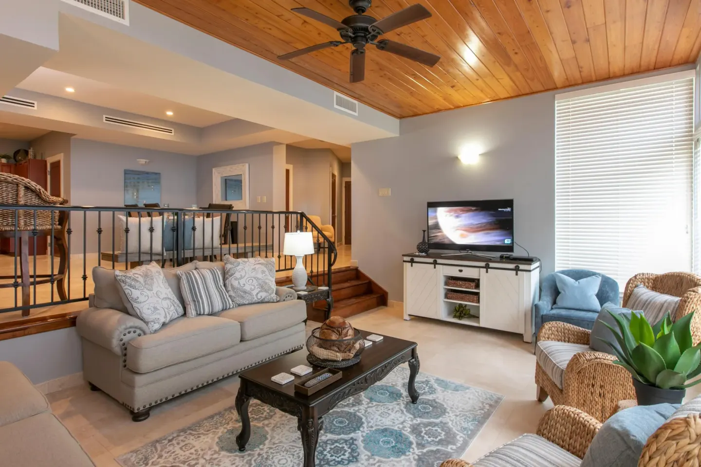 Split-level living room with sofa, TV, and wicker chairs at The Hills, St John.