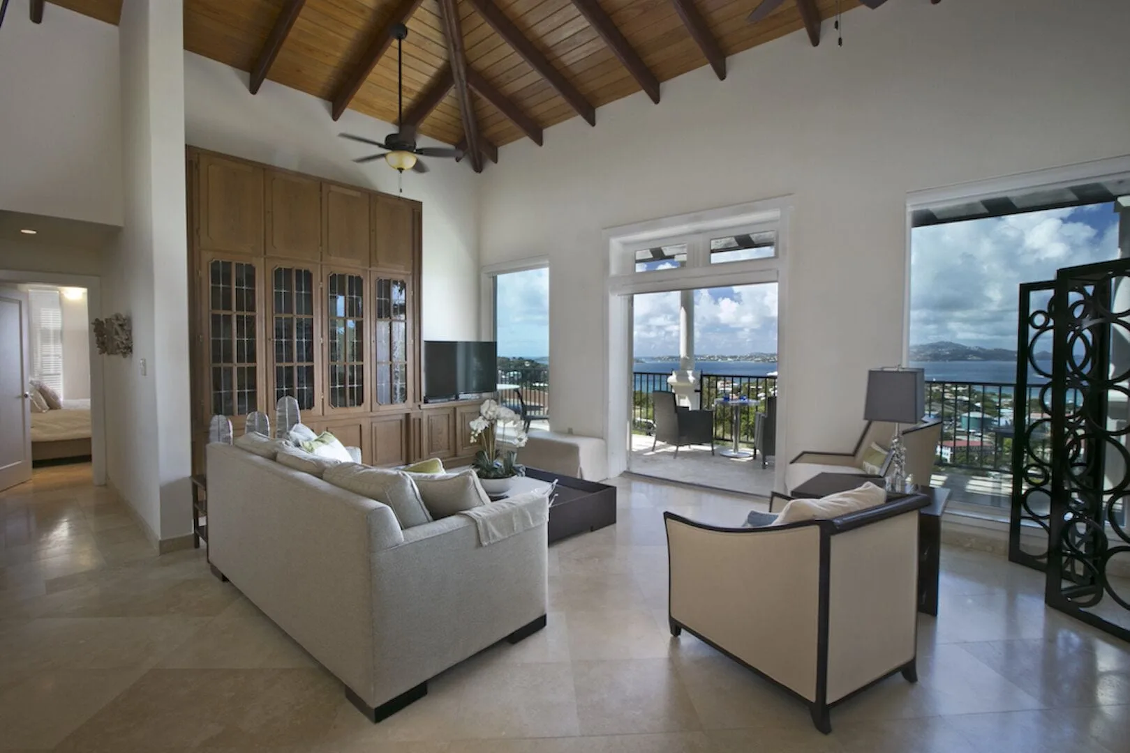 Vaulted living room with balcony doors and water views at The Hills, St John.