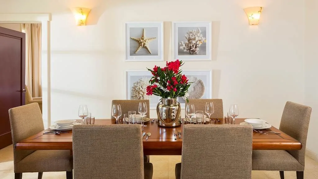 Dining table with upholstered chairs and red flowers at The Hills, St John.
