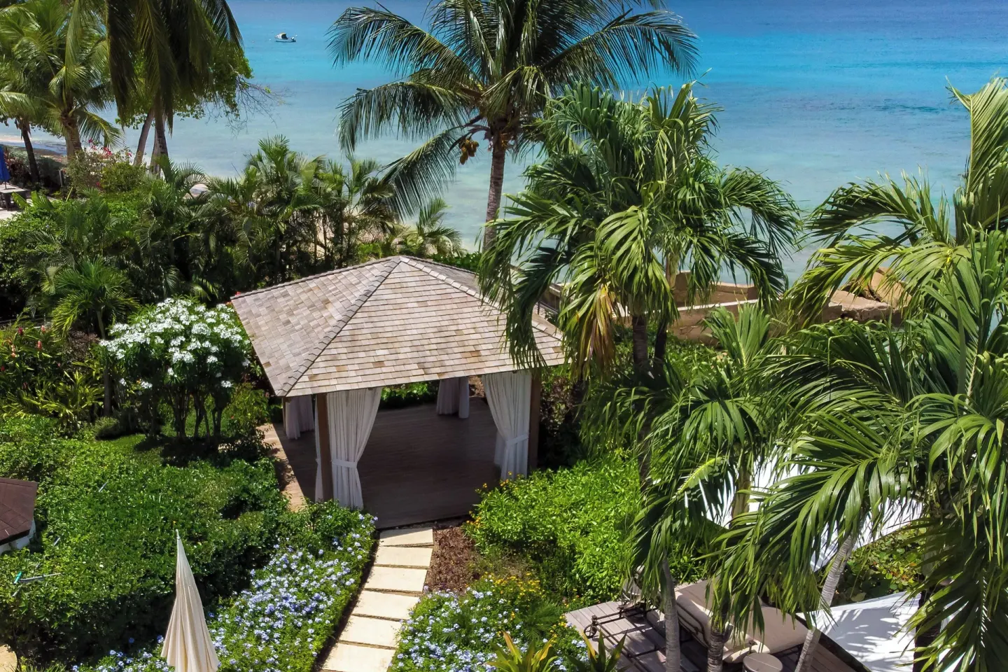 Garden pavilion among palms overlooking the beach and turquoise sea at The House.