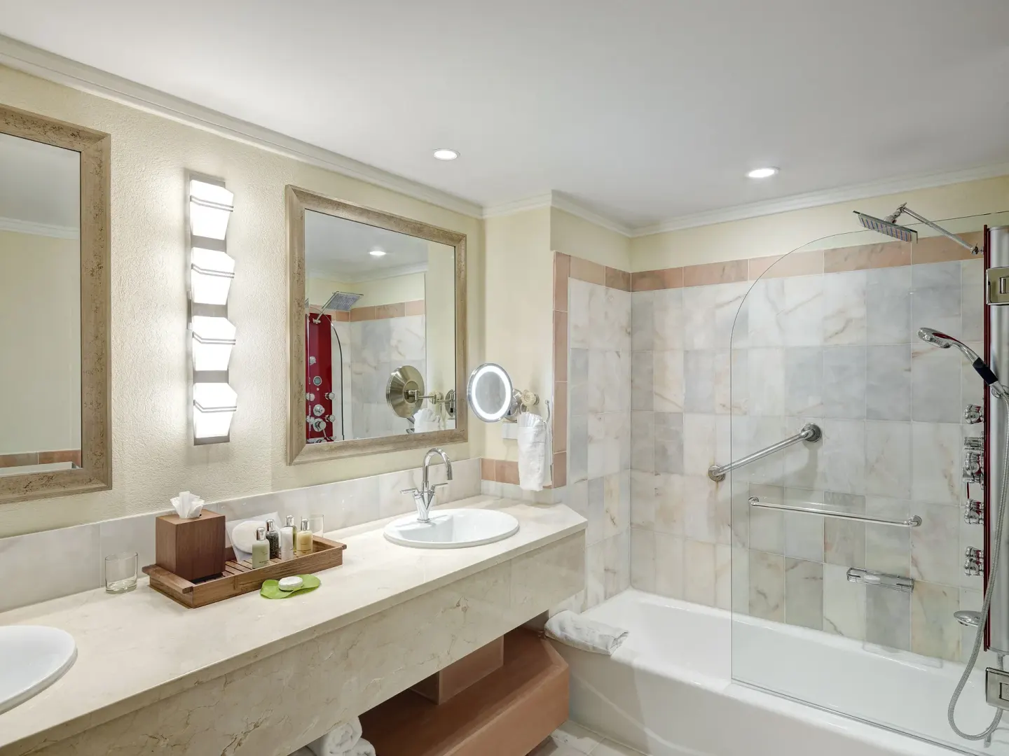 Marble bathroom with double vanity and glass tub shower at The House.