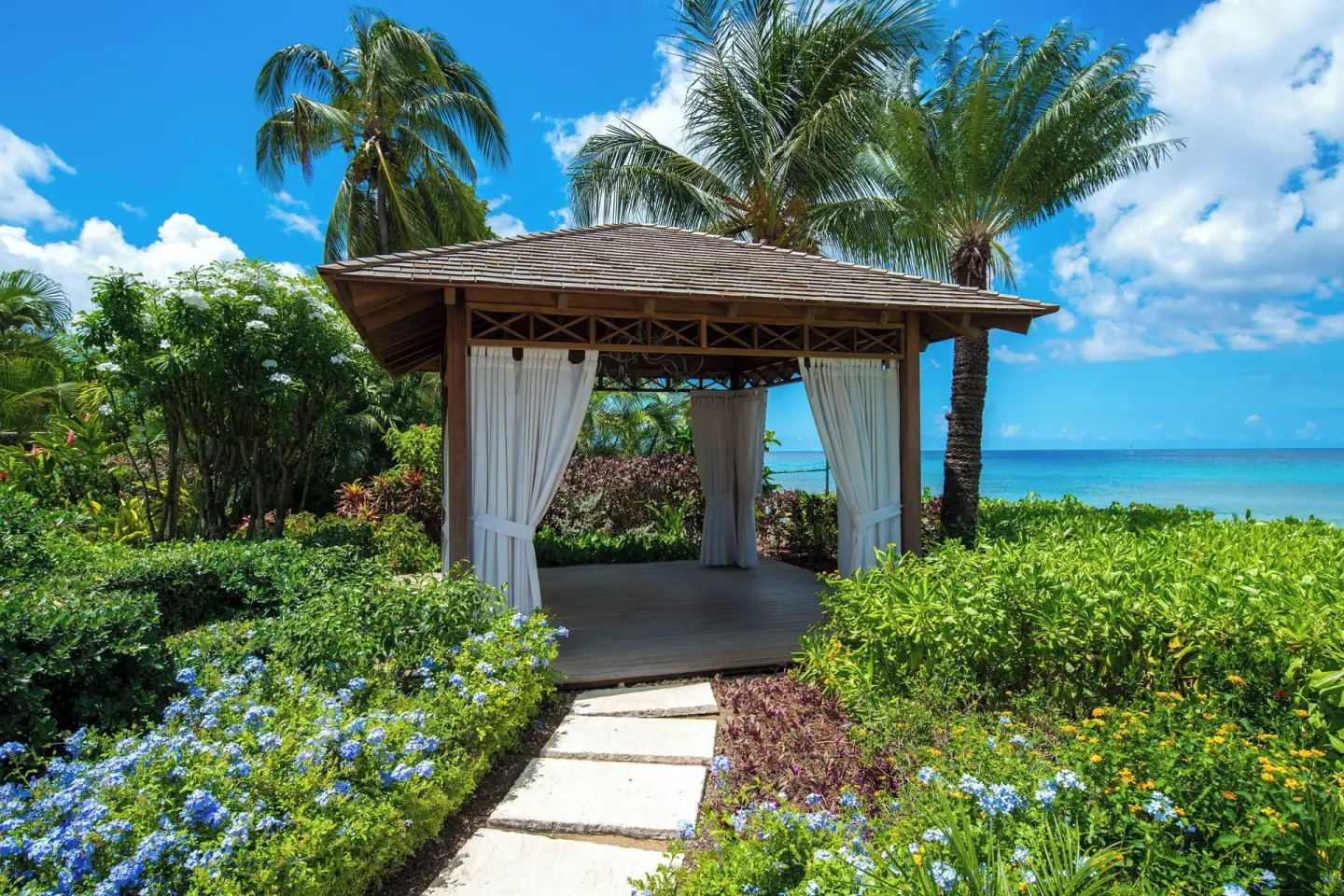 Garden gazebo with white curtains beside the sea at The House.