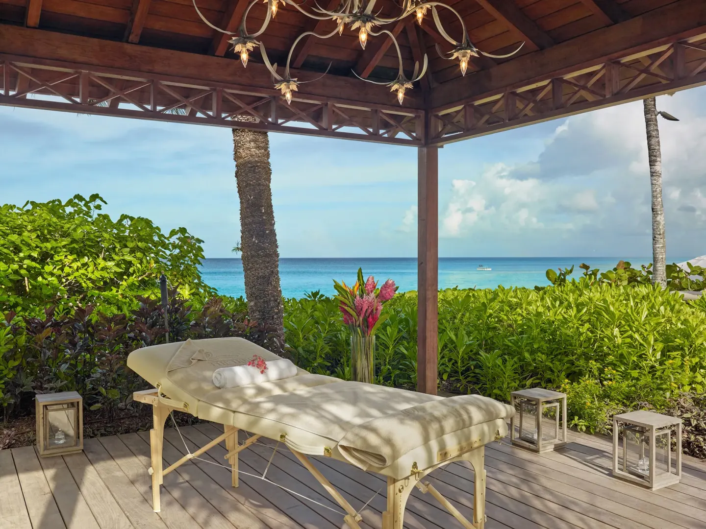 Outdoor massage table under a wooden pavilion with ocean views at The House.