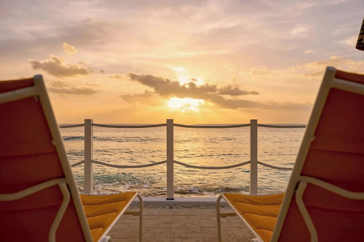 Sun loungers face the ocean at sunset from The House.
