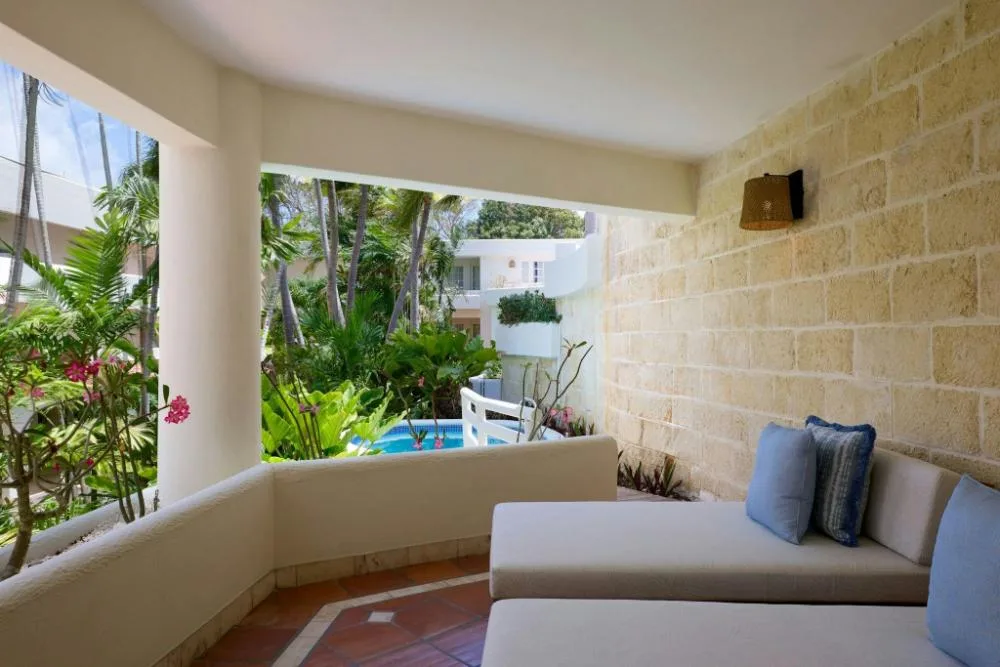 Garden-view patio with cushioned lounger outside a Luxury Garden View room at The House.