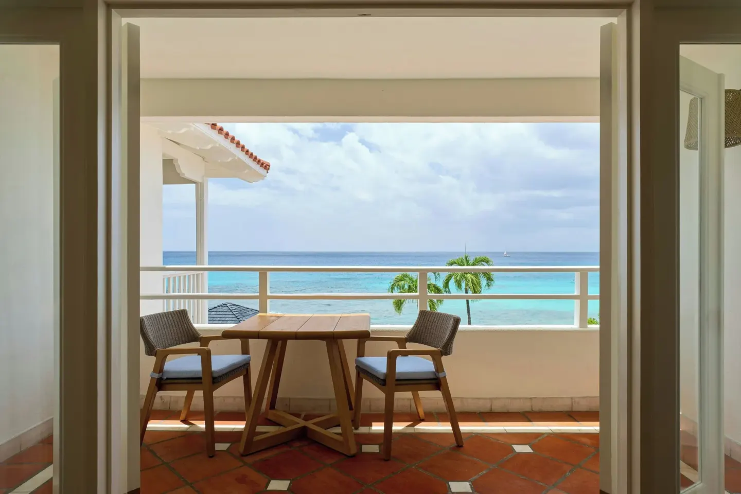 Ocean View 1 Bedroom Suite balcony with table, chairs and sea view at The House.