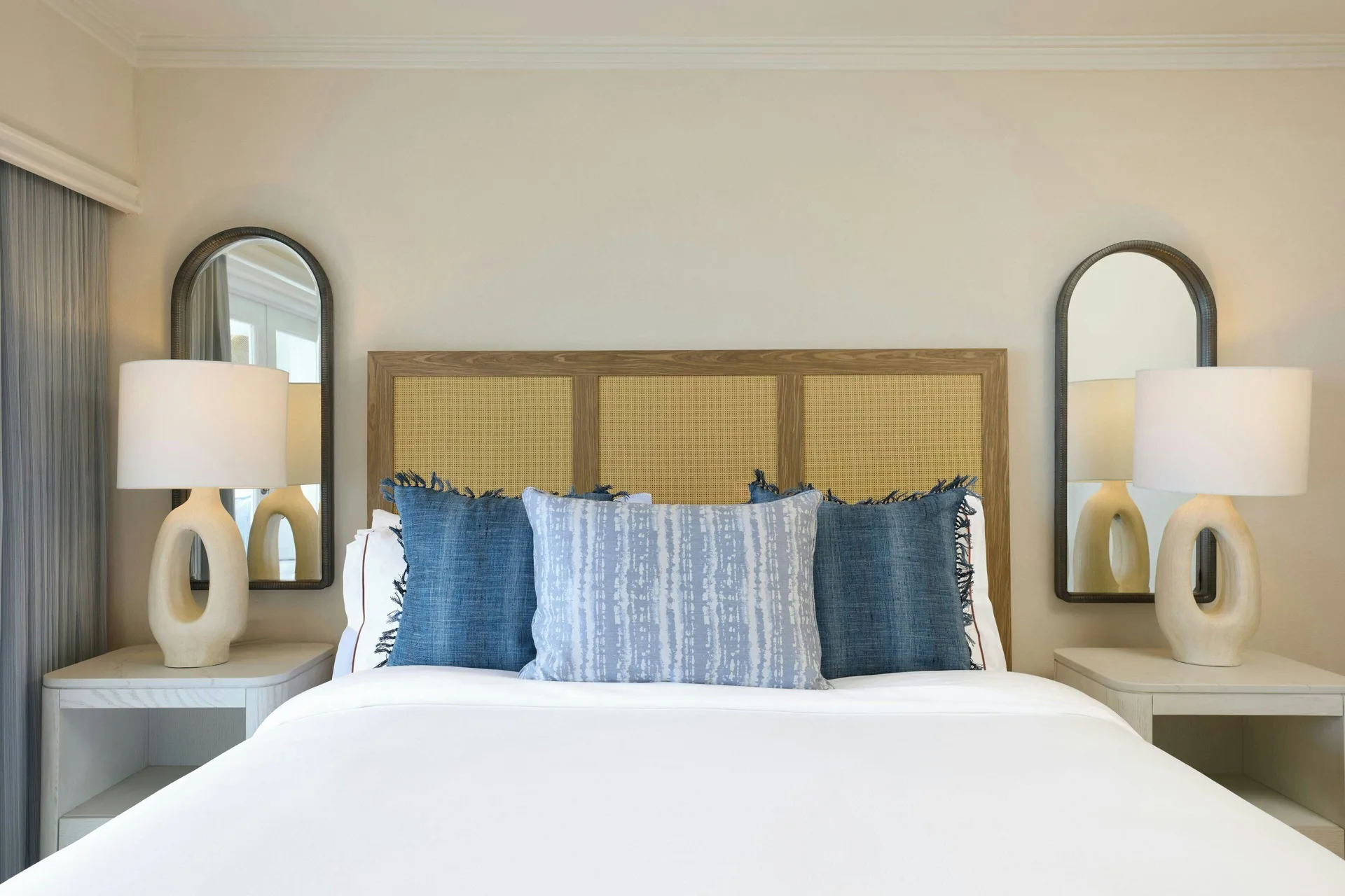Ocean View 1 Bedroom Suite king bed with blue pillows and bedside lamps at The House.