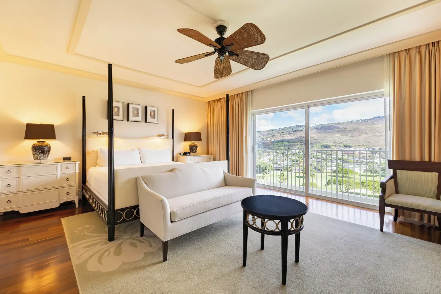 King bed guest room with sofa and mountain-view balcony at The Kahala Hotel & Resort.