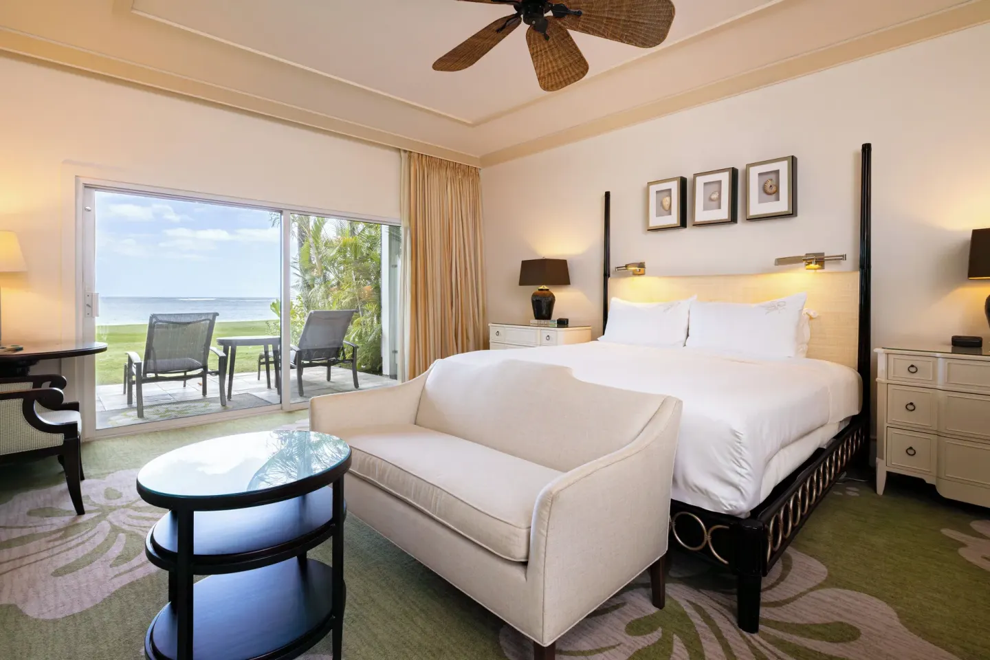 King bed guest room with sofa and oceanfront patio at The Kahala Hotel & Resort.