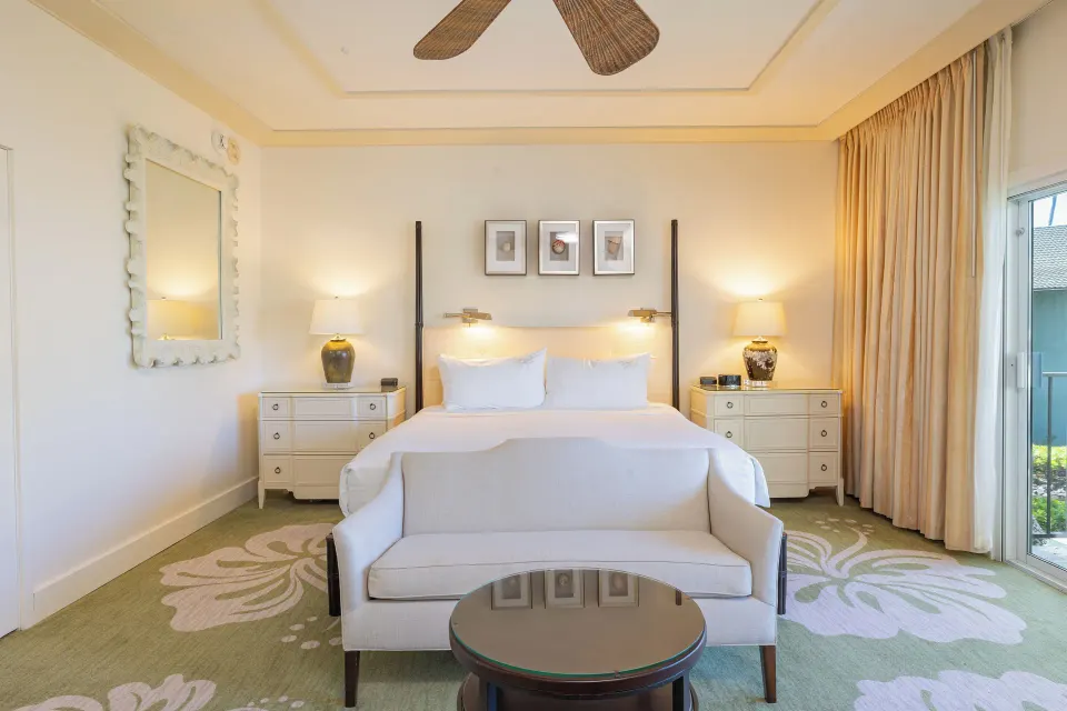 King bed guest room with sofa and balcony doors at The Kahala Hotel & Resort.