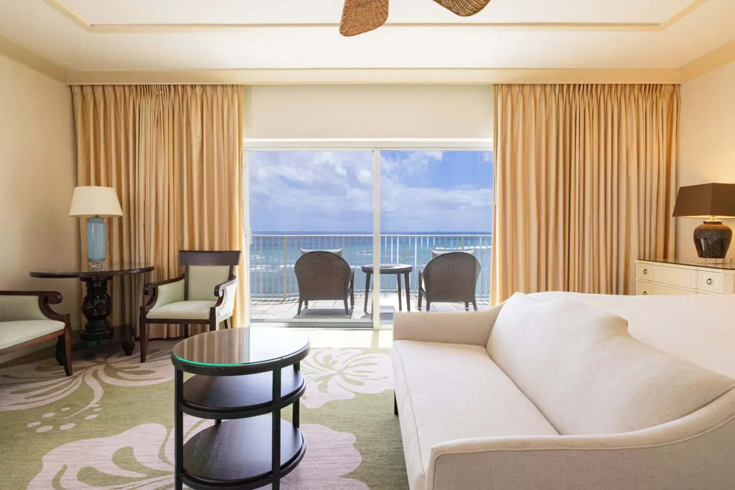 Sitting area with sofa and ocean-view balcony at The Kahala Hotel & Resort.