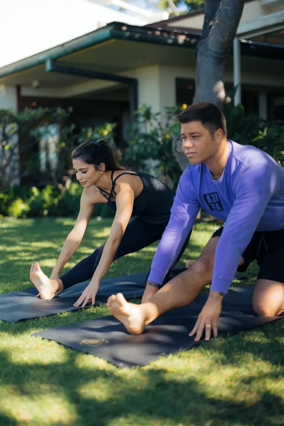 Guests stretching on yoga mats outdoors at The Kahala Hotel & Resort.