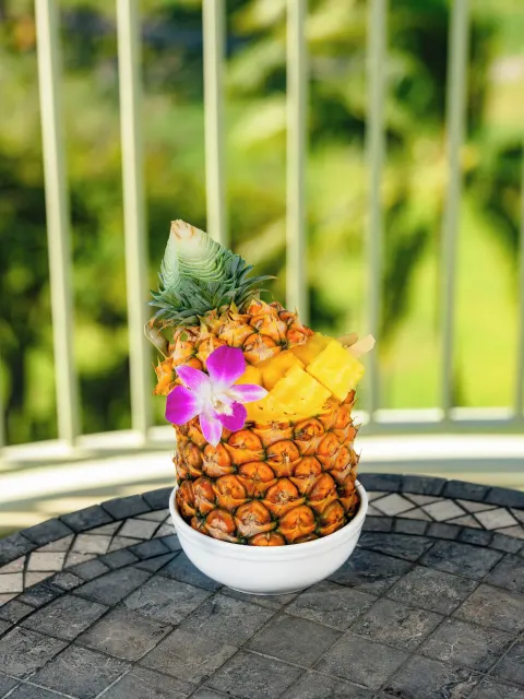 Pineapple bowl with diced fruit on a balcony at The Kahala Hotel & Resort.