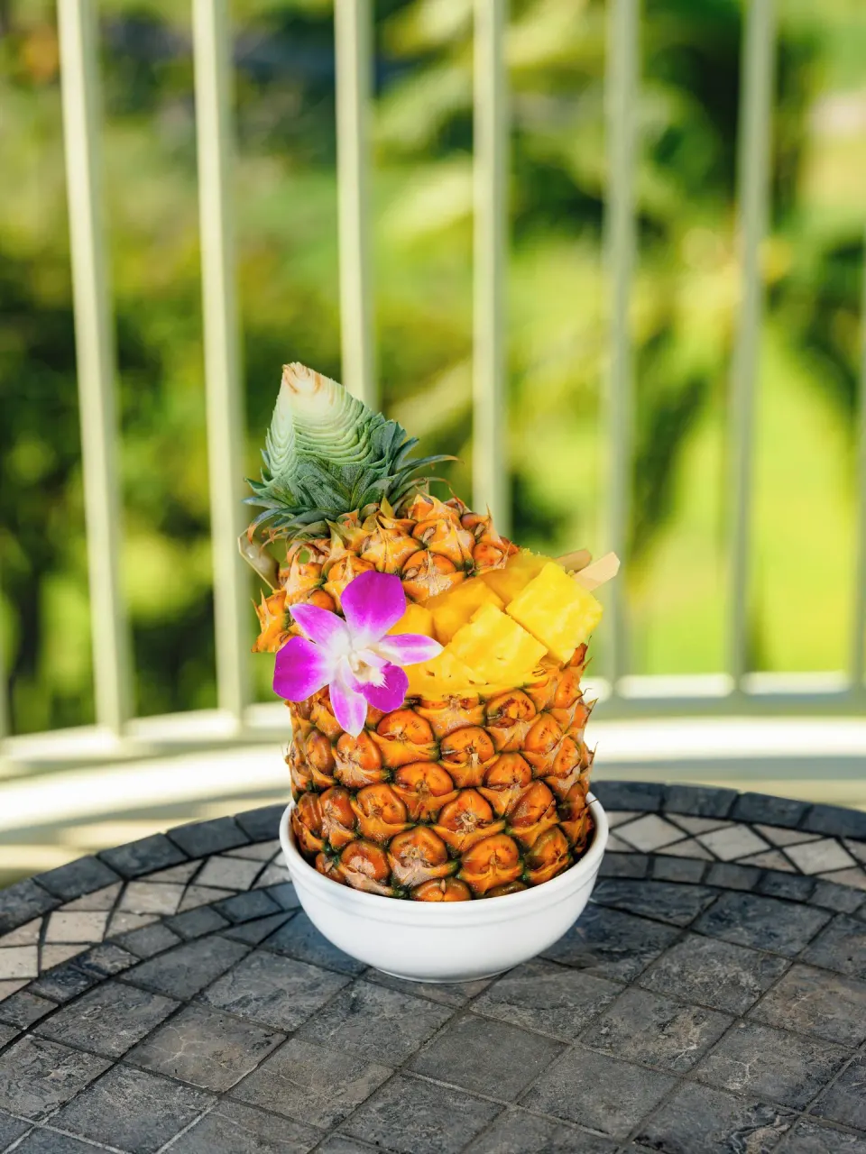 Pineapple bowl with diced fruit on a balcony at The Kahala Hotel & Resort.