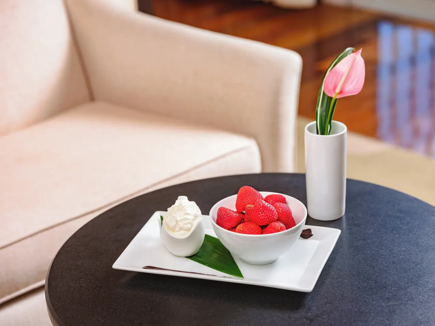 Bowl of strawberries with cream on a table at The Kahala Hotel & Resort.