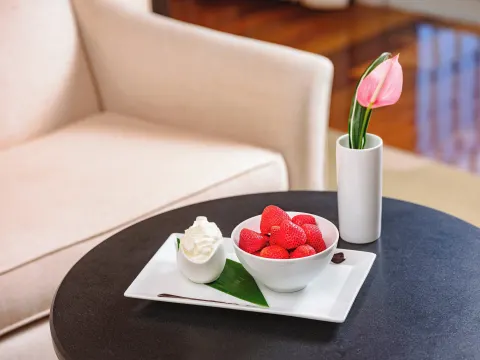 Bowl of strawberries with cream on a table at The Kahala Hotel & Resort.