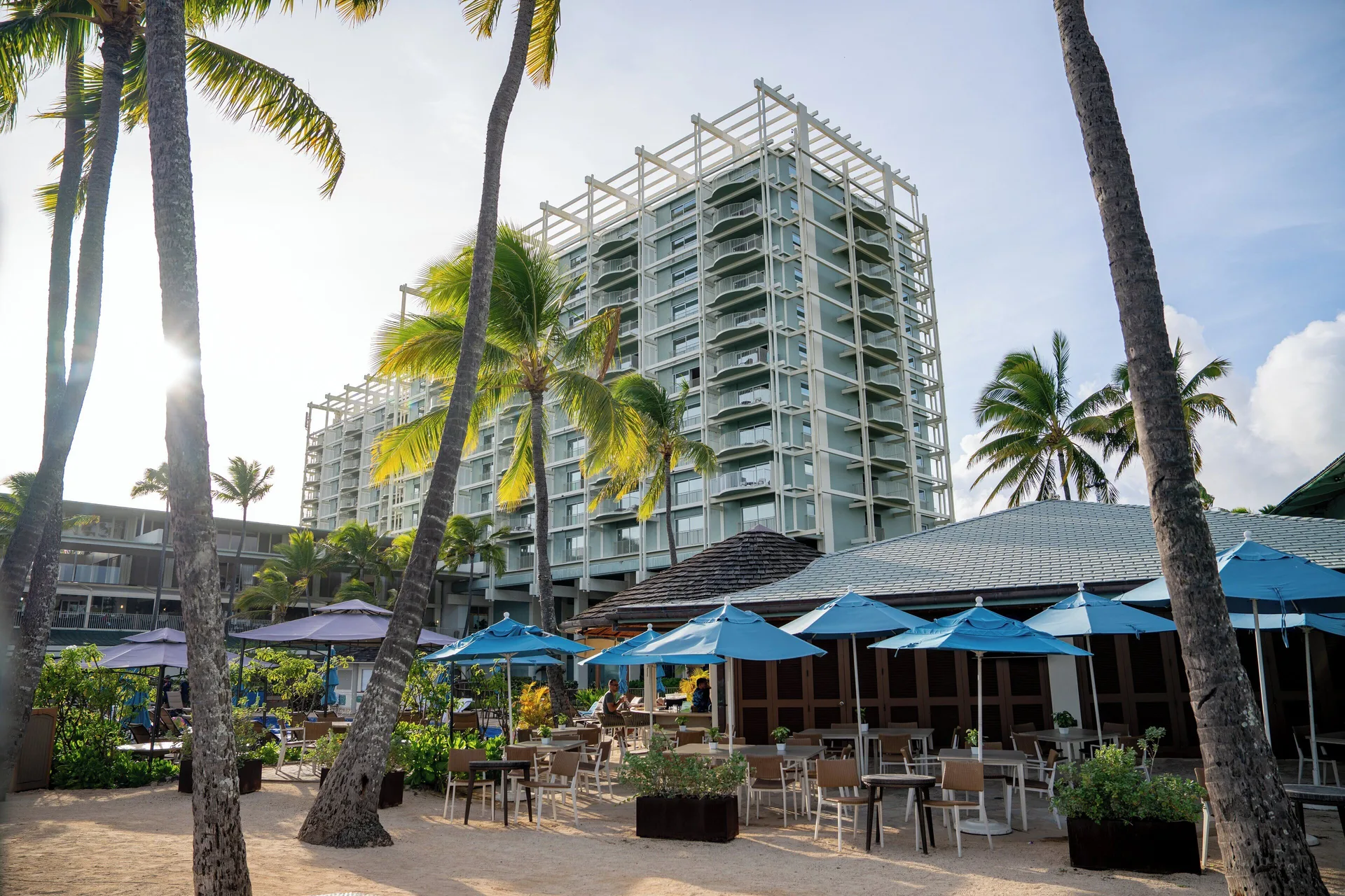 Outdoor beachfront patio with blue umbrellas at The Kahala Hotel & Resort.