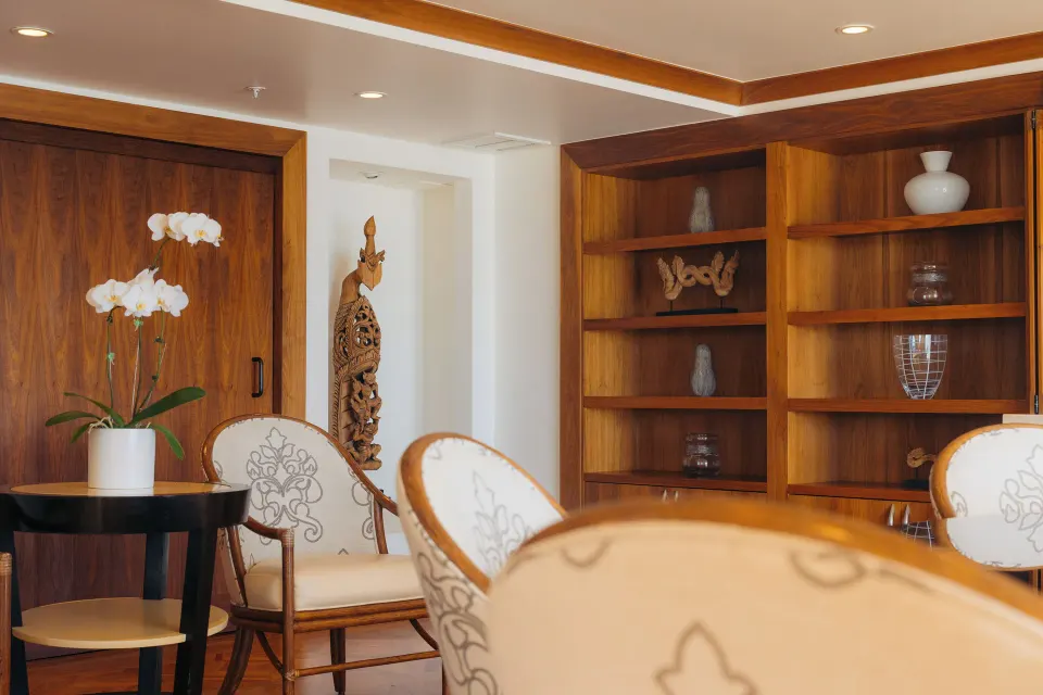 Imperial Suite dining area with orchid and display shelves at The Kahala Hotel & Resort.