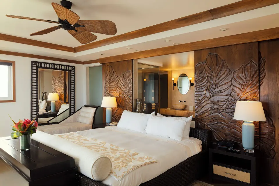 Imperial Suite king bedroom with carved wood wall panels at The Kahala Hotel & Resort.