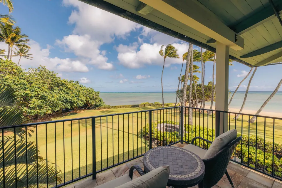 The Kahala Hotel & Resort lanai overlooking lawn, palms, and ocean at The Kahala Hotel & Resort.
