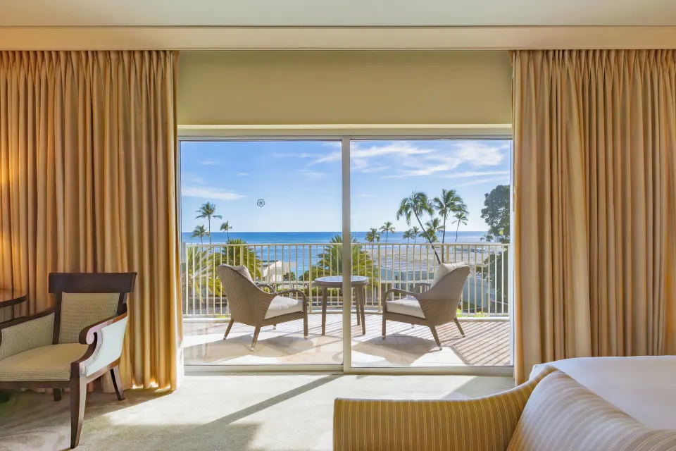 Ocean View Lanai balcony seating and ocean seen through glass doors at The Kahala Hotel & Resort.