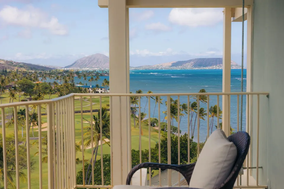 Partial Ocean View Suite balcony with ocean, palms, and coastline at The Kahala Hotel & Resort.
