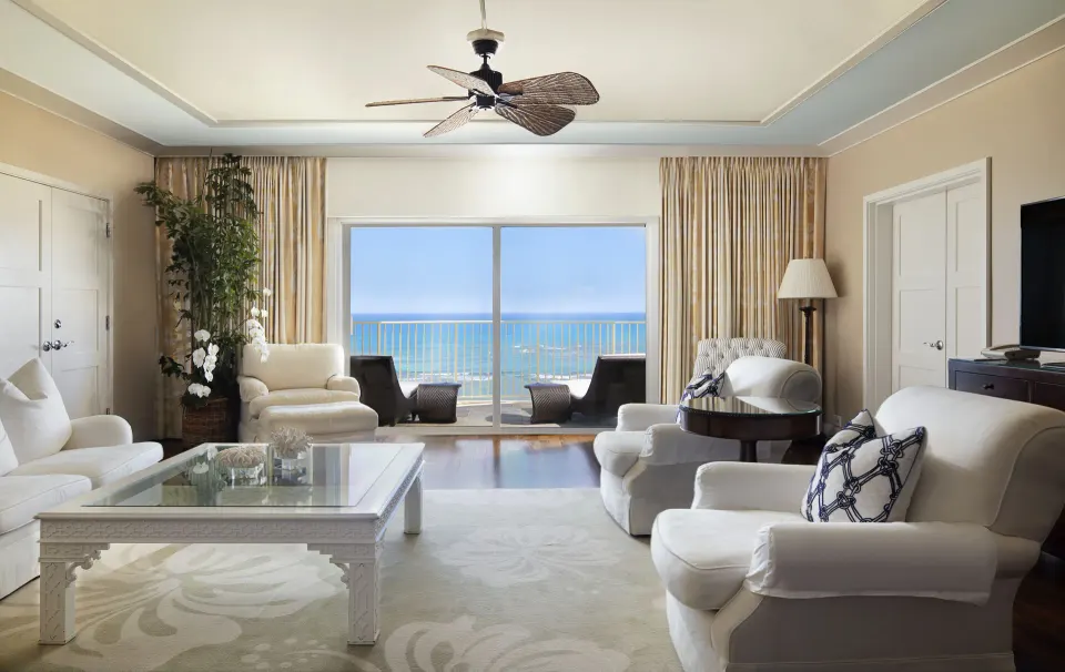 Tower Suite I living room with white seating and ocean balcony at The Kahala Hotel & Resort.