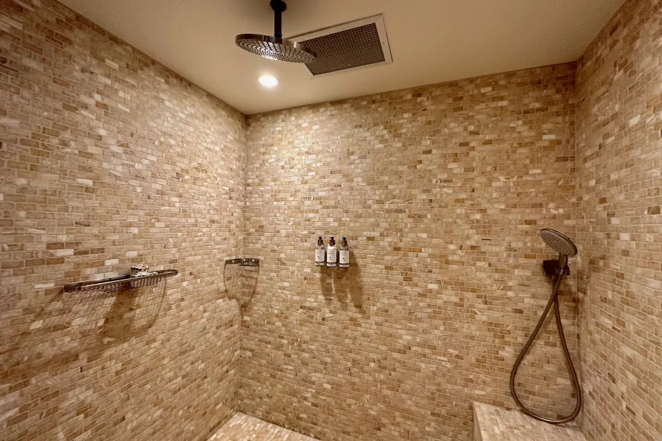 Tower Suite I tiled walk-in shower with rainfall and handheld fixtures at The Kahala Hotel & Resort.