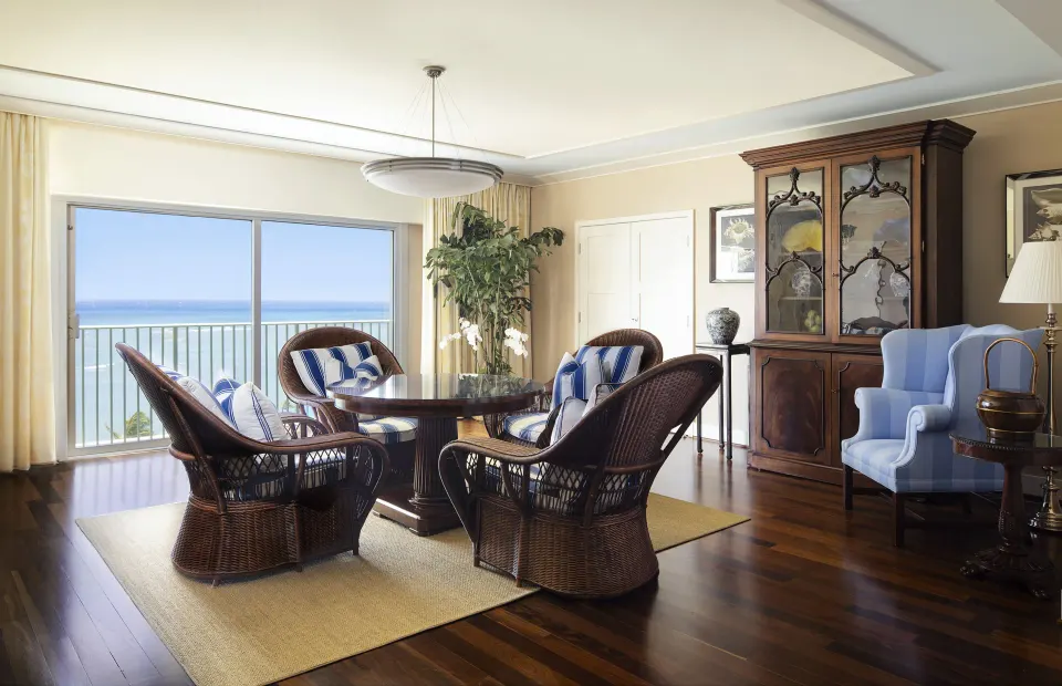 Tower Suite II lounge with wicker chairs and ocean view at The Kahala Hotel & Resort.
