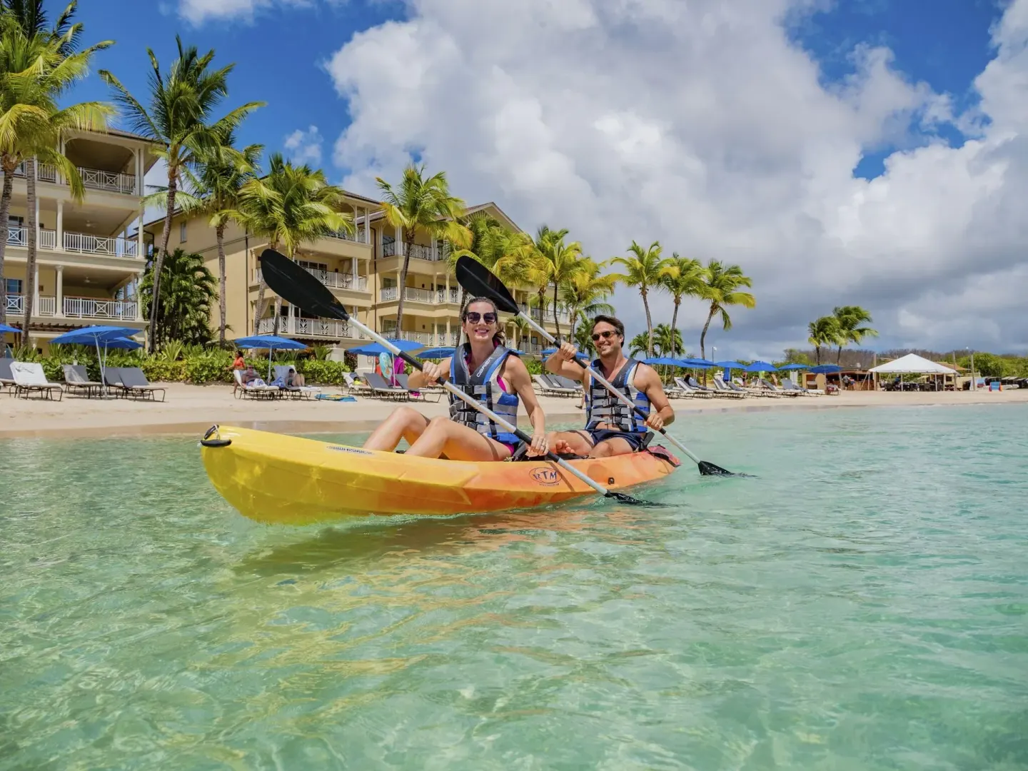 Two guests kayaking in clear water off the beach at The Landings Resort & Spa.