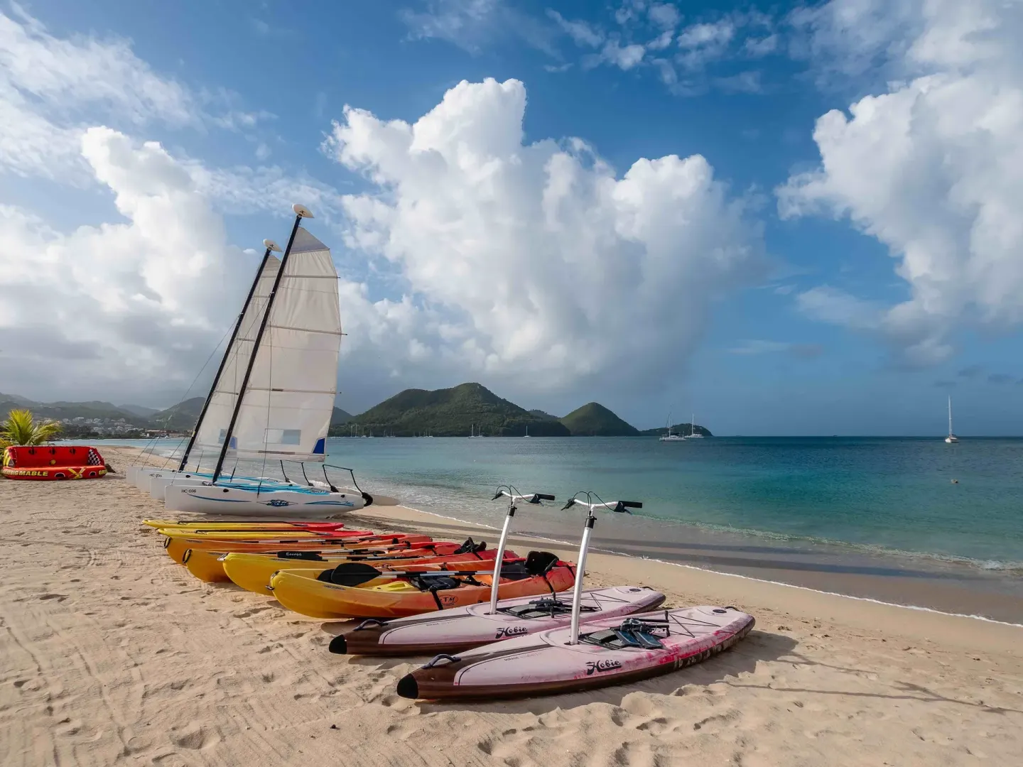 Paddleboards, kayaks and a sailboat on the beach at The Landings Resort & Spa.
