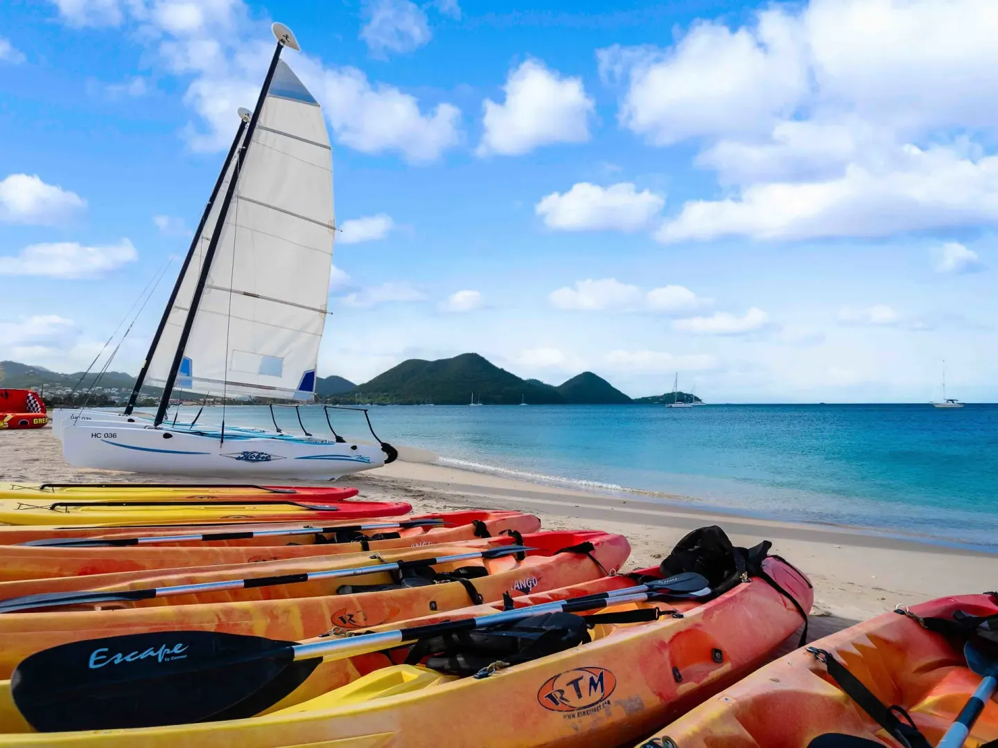 Kayaks and a sailboat lined up on the beach at The Landings Resort & Spa.