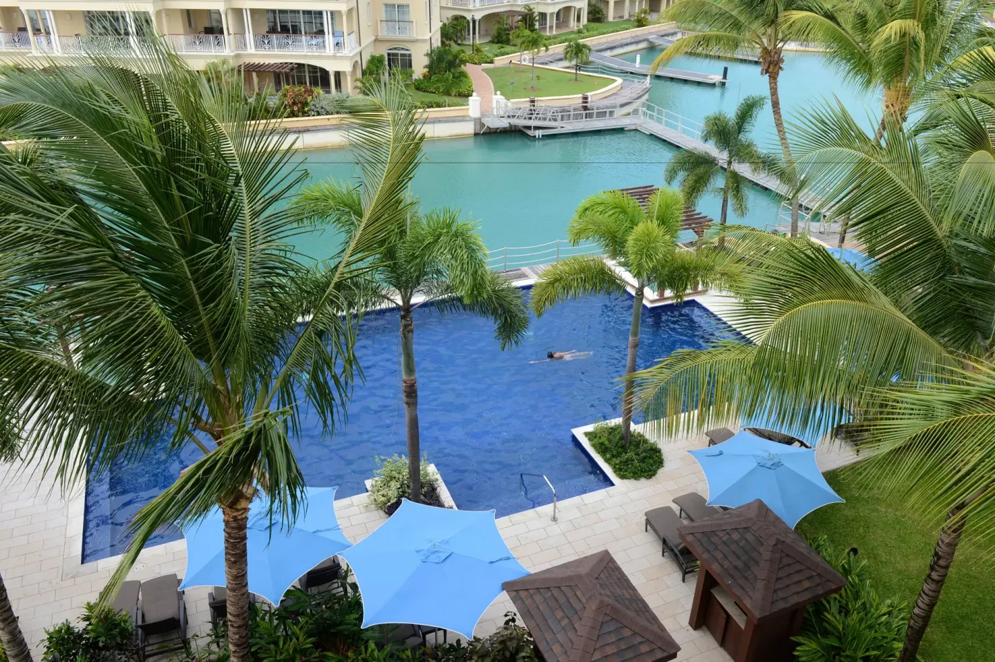 Palm-framed pool, umbrellas and marina water at The Landings Resort & Spa.