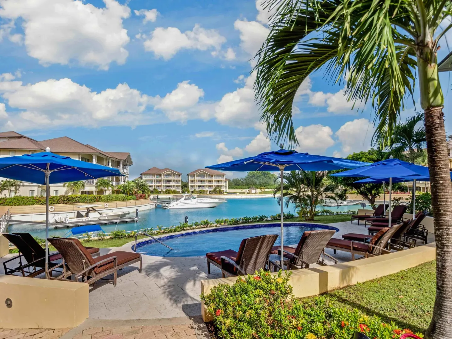 Poolside loungers under blue umbrellas beside the marina at The Landings Resort & Spa.
