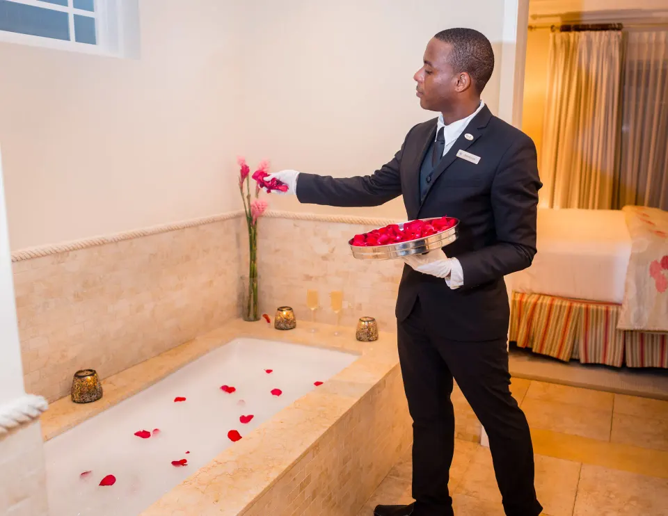 Staff member placing rose petals by a bathtub at The Landings Resort & Spa.
