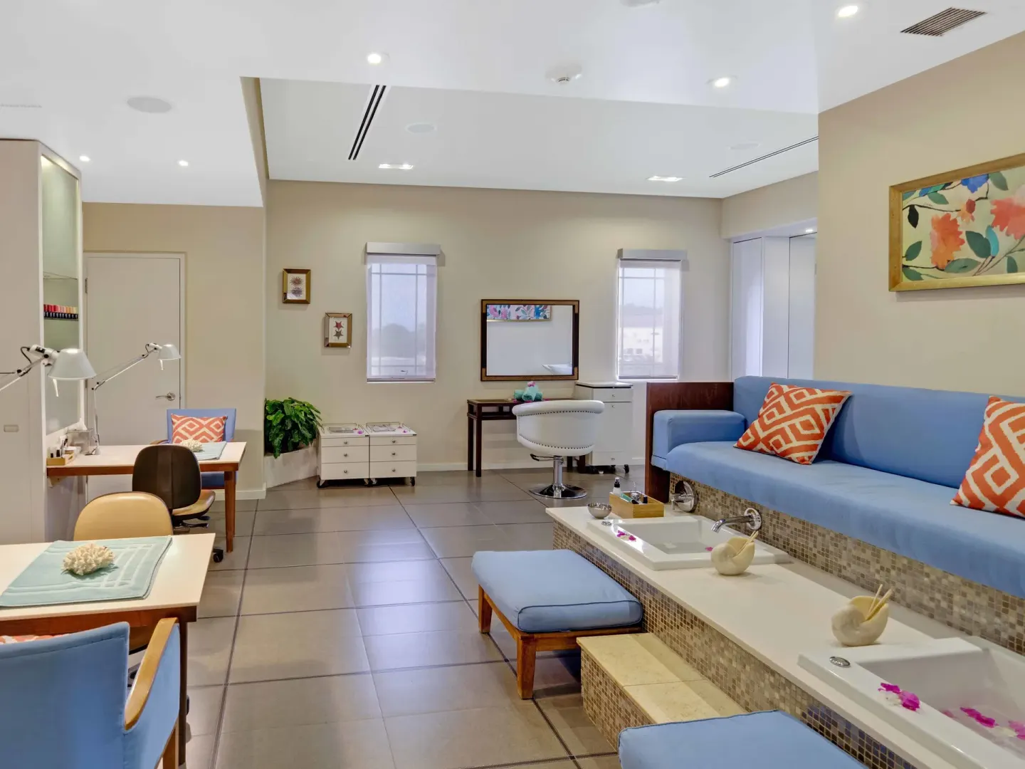 Spa pedicure lounge with blue seating and foot basins at The Landings Resort & Spa.