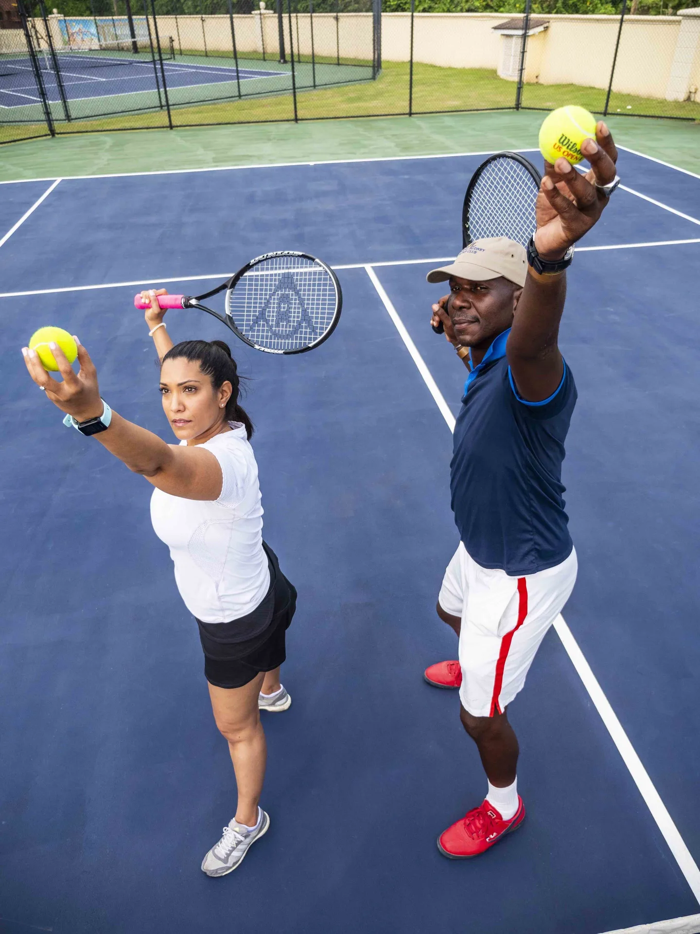Two tennis players posing with racquets and balls at The Landings Resort & Spa.