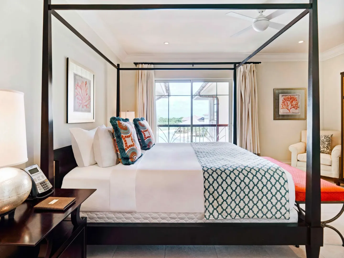 Canopy bed facing a balcony in a villa suite at The Landings Resort & Spa.