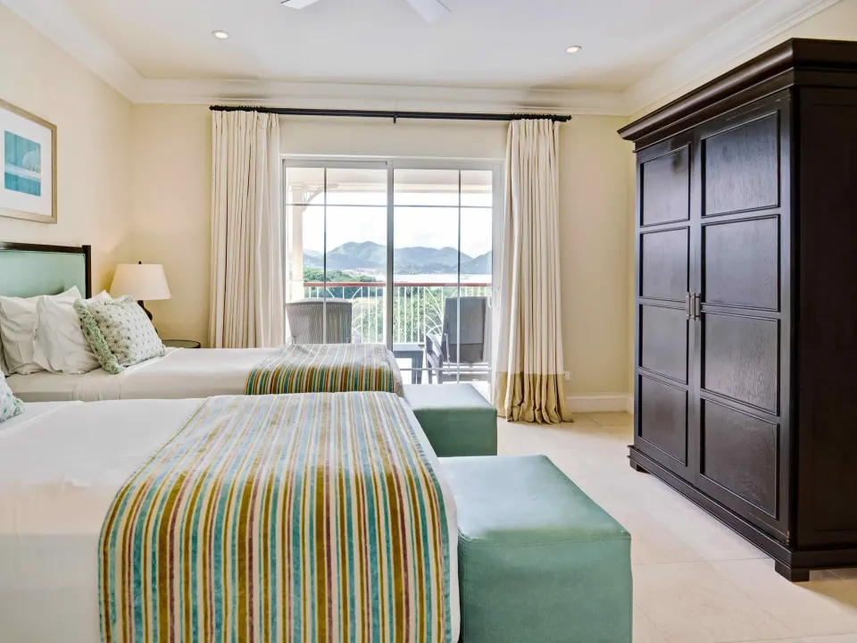Twin bedroom in a marina view villa suite at The Landings Resort & Spa with balcony and mountain view.
