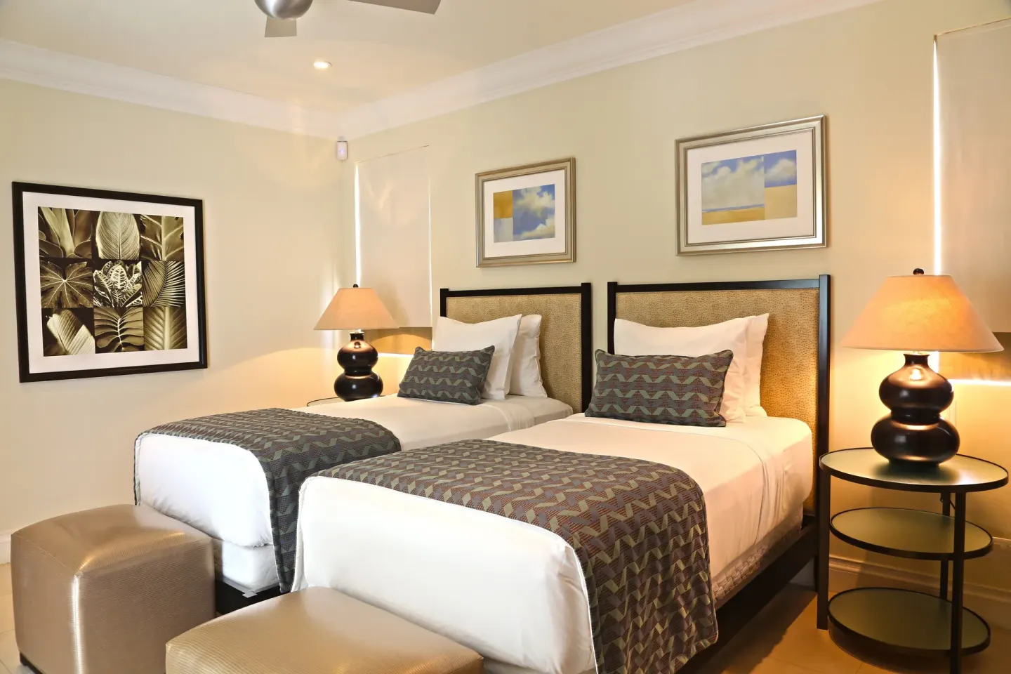 Twin bedroom in a 2 Bedroom Marina View Villa Suite at The Landings Resort & Spa with lamps and wall art.