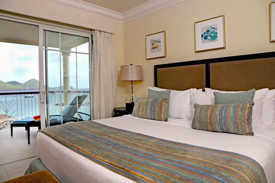 King bedroom at The Landings Resort & Spa with balcony doors and a view of the water.