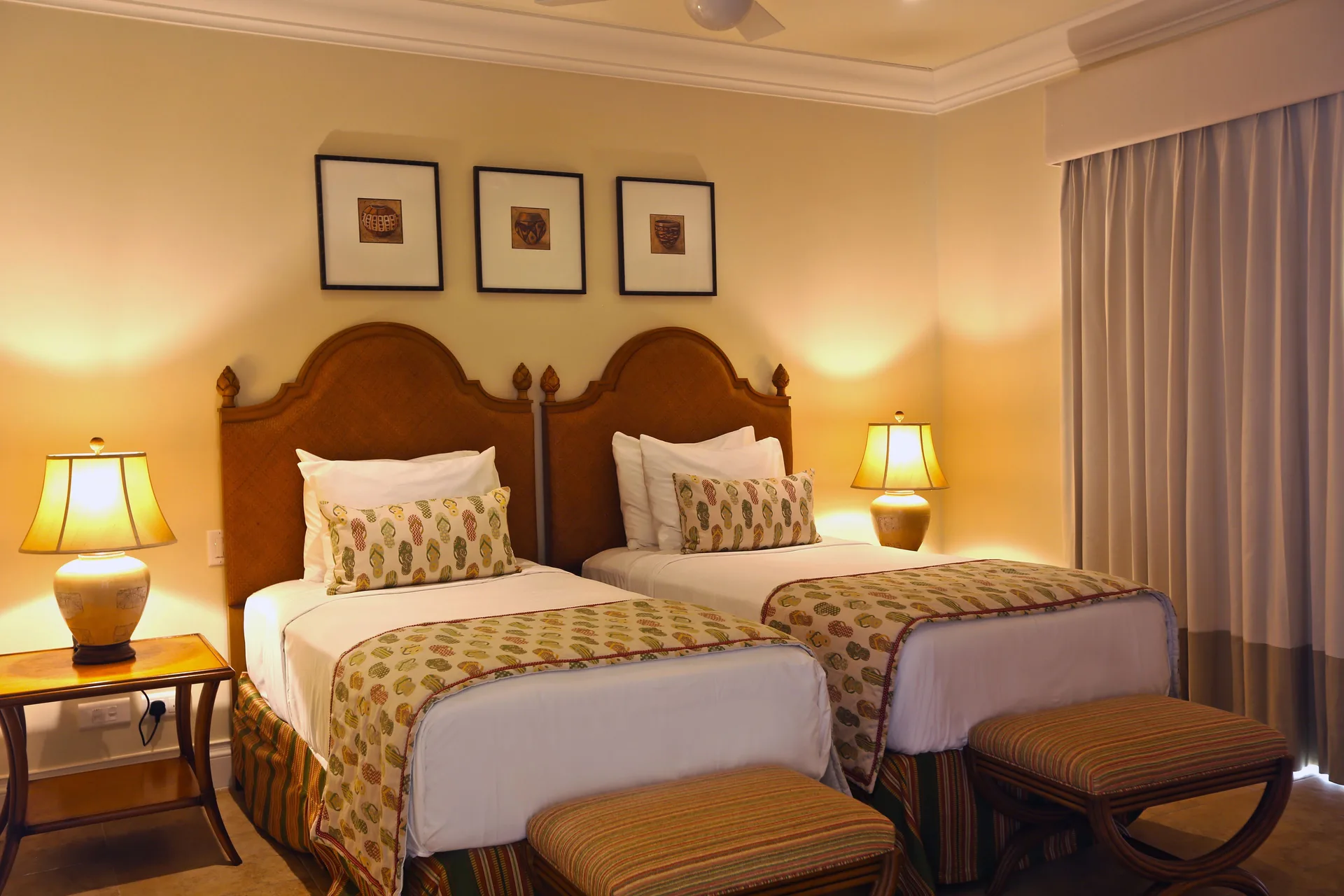 Twin-bed guest room in a villa suite at The Landings Resort & Spa with lamps and framed wall art.