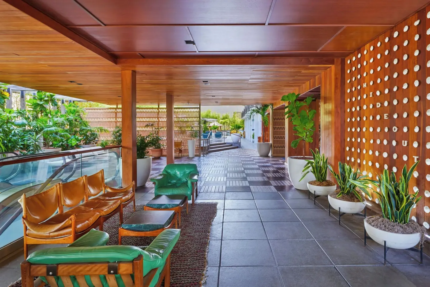 Covered walkway with Hideout wall and lounge seating at The Laylow Waikiki, Autograph Collection.
