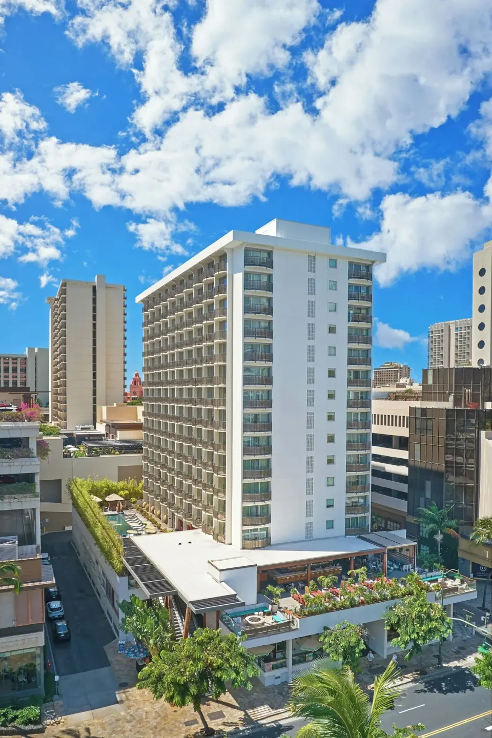 Daytime exterior of The Laylow Waikiki, Autograph Collection with balconies and a rooftop terrace.